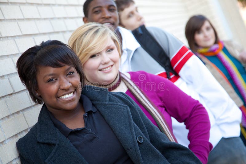 Étudiants universitaires Multi-racial contre un mur de briques photo stock Étudiants universitaires Multi-racial contre un mur de briques photo stock