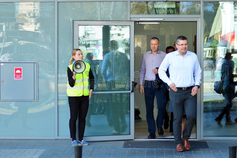Évacuation d'un immeuble de bureaux Les gens sortent le bâtiment sur la porte de sortie images stock Évacuation d'un immeuble de bureaux Les gens sortent le bâtiment sur la porte de sortie images stock