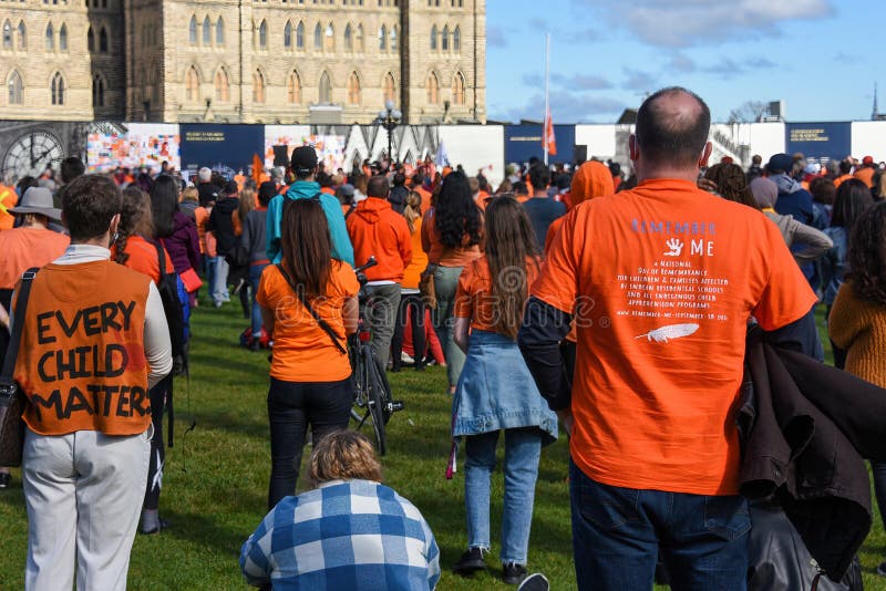 Ottawa, Canada - Sep 30, 2021: A crowd of people gathers on Parliament Hill for event on The National Day for Truth and Reconciliation, aka Orange Shirt Day. The day was proclaimed to be.a statutory holiday by the Canadian government for the first time in 2021 in light of the revelations of over 1,000 unmarked graves near former residential school sites. Ottawa, Canada - Sep 30, 2021: A crowd of people gathers on Parliament Hill for event on The National Day for Truth and Reconciliation, aka Orange Shirt Day. The day was proclaimed to be.a statutory holiday by the Canadian government for the first time in 2021 in light of the revelations of over 1,000 unmarked graves near former residential school sites