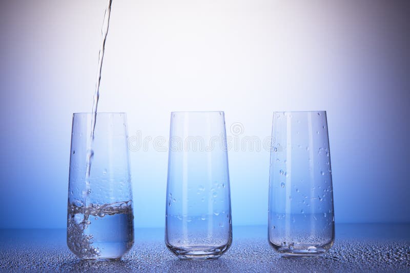 Één derdehoogtepunt, twee lege het drinken glazen Water het gieten royalty-vrije stock foto's Één derdehoogtepunt, twee lege het drinken glazen Water het gieten royalty-vrije stock foto's