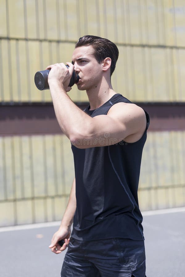 Één jonge Kaukasische atletische mens is drinkwater van een fles stock afbeeldingen Één jonge Kaukasische atletische mens is drinkwater van een fles stock afbeeldingen