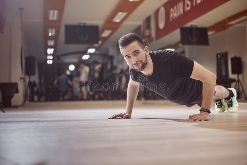 Één jonge mensenduw op oefening op gymnastiekvloer royalty-vrije stock foto's Één jonge mensenduw op oefening op gymnastiekvloer royalty-vrije stock foto's