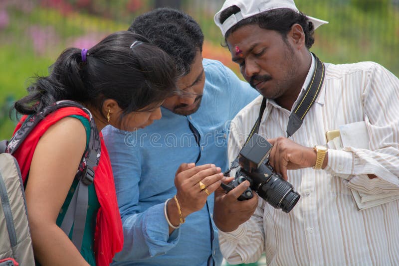 Índia de Bangalore, Karnataka 4 de junho de 2019: O fotógrafo indiano que mostra fotos aos clientes na tela da câmera da foto, ac imagem de stock royalty free Índia de Bangalore, Karnataka 4 de junho de 2019: O fotógrafo indiano que mostra fotos aos clientes na tela da câmera da foto, ac imagem de stock royalty free