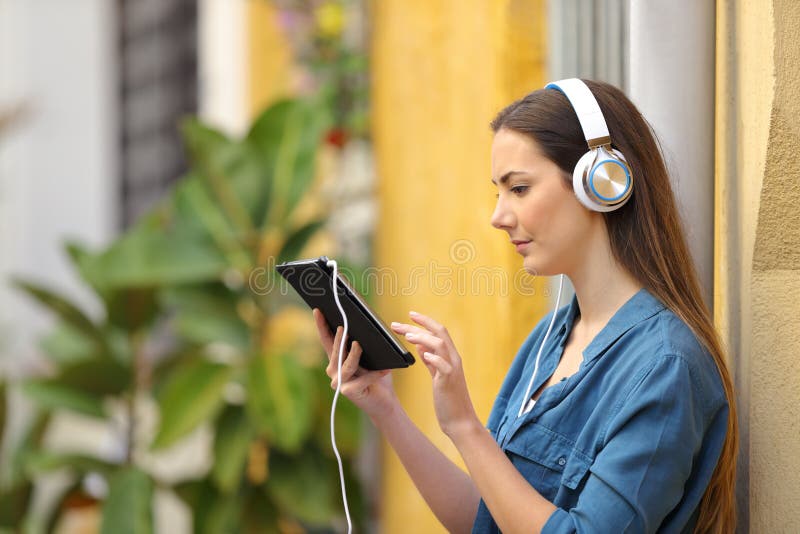 Índice de escuta e de observação da menina séria da tabuleta imagem de stock Índice de escuta e de observação da menina séria da tabuleta imagem de stock