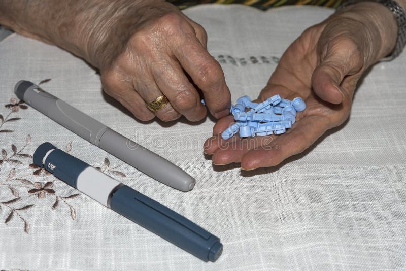 Διαβητική ηλικιωμένη κυρία που προετοιμάζει τις βελόνες για να εγχύσει τη δόση ινσουλίνης της στοκ εικόνες Διαβητική ηλικιωμένη κυρία που προετοιμάζει τις βελόνες για να εγχύσει τη δόση ινσουλίνης της στοκ εικόνες