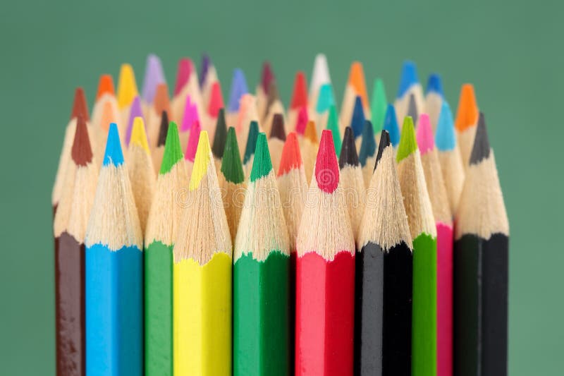 închiderea extremă a unui grup mare de penextrem colorat, aproape de un grup mare de creioane colorate pe fond verde stock image