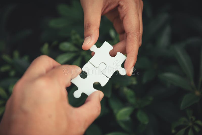 închiderea mâinilor bărbătești și ale femeilor care unesc puzzle-ul stock photo