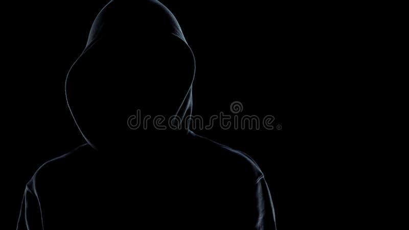 închiderea unei siluete masculine fără față în picioare împotriva unui criminal de fond negru stock photography