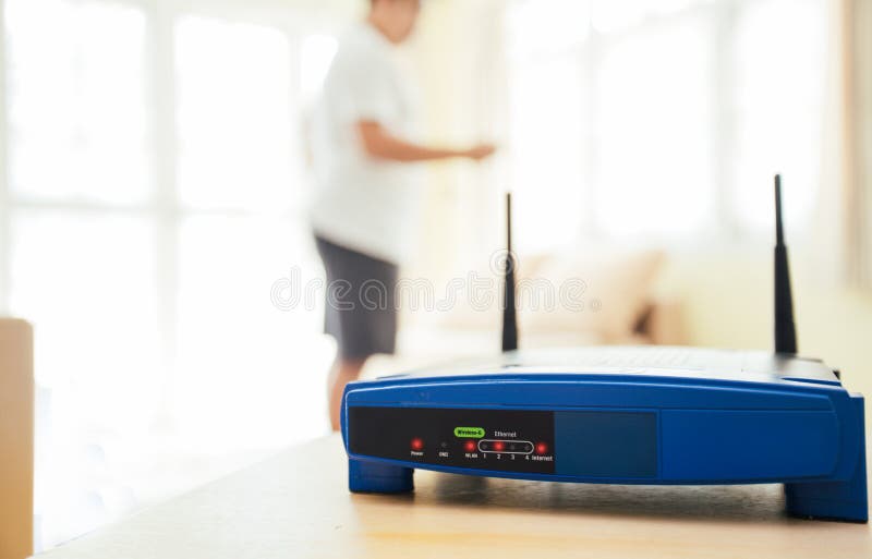 închiderea unui router wireless și a unui tânăr care utilizează laptopuri și laptopuri în sufragerie, în locuință, cu o fereastră royalty free stock photos