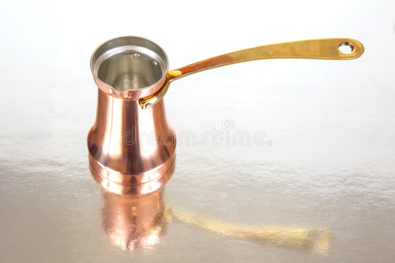 Închiderea unui vas tradițional de cafea turcesc din cupru, cu un mâner lung din alamă, izolat pe un fundal alb, perfect pentru ac royalty free stock photos