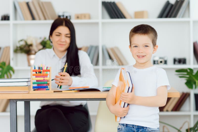 învățătoare fericită care dă lecții personale fetiței zâmbitoare după școală royalty free stock photo