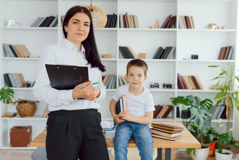 învățătoare fericită care dă lecții personale fetiței zâmbitoare după școală royalty free stock photo