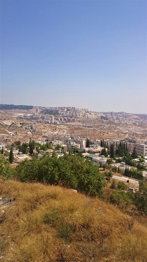 Άποψη μιας νέας περιοχής στην Ιερουσαλήμ, ενάντια σε έναν μπλε ουρανό και έναν κίτρινο χορτοτάπητα με την ξηρά χλόη, Ισραήλ στοκ φωτογραφίες με δικαίωμα ελεύθερης χρήσης Άποψη μιας νέας περιοχής στην Ιερουσαλήμ, ενάντια σε έναν μπλε ουρανό και έναν κίτρινο χορτοτάπητα με την ξηρά χλόη, Ισραήλ στοκ φωτογραφίες με δικαίωμα ελεύθερης χρήσης