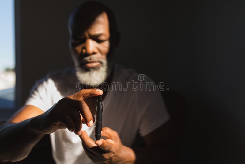 Ανώτερο άτομο με το glucometer που ελέγχει το επίπεδο ζάχαρης αίματος στο σπίτι στοκ εικόνα Ανώτερο άτομο με το glucometer που ελέγχει το επίπεδο ζάχαρης αίματος στο σπίτι στοκ εικόνα