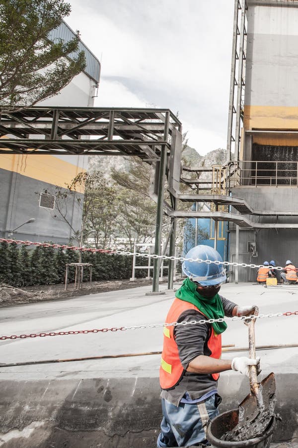 Αρσενικό ασιατικό laborer με τα λύματα φτυαριών cleanout στον υπόνομο στο εργοστάσιο τσιμέντου Έννοια σκληρής δουλειάς στοκ φωτογραφία με δικαίωμα ελεύθερης χρήσης Αρσενικό ασιατικό laborer με τα λύματα φτυαριών cleanout στον υπόνομο στο εργοστάσιο τσιμέντου Έννοια σκληρής δουλειάς στοκ φωτογραφία με δικαίωμα ελεύθερης χρήσης