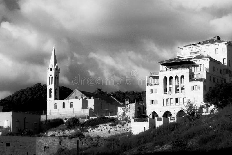 Αστική άποψη μεσημβρίας μιας εκκλησίας και ενός ενδιαφέροντος σπιτιού αρχιτεκτονικής με τέσσερα πατώματα, μπαλκόνια και αψίδες, κ στοκ εικόνα με δικαίωμα ελεύθερης χρήσης Αστική άποψη μεσημβρίας μιας εκκλησίας και ενός ενδιαφέροντος σπιτιού αρχιτεκτονικής με τέσσερα πατώματα, μπαλκόνια και αψίδες, κ στοκ εικόνα με δικαίωμα ελεύθερης χρήσης