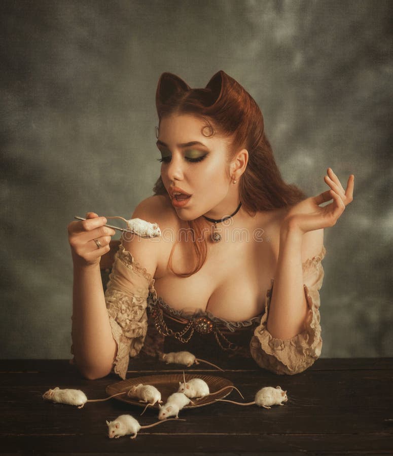 Γοητευτικός τη redhead κυρία με τα αυτιά γατών φιαγμένα από τρίχα που πηγαίνει να φάει το άσπρο ποντίκι στο δίκρανο Η κοντέσα pus στοκ εικόνες Γοητευτικός τη redhead κυρία με τα αυτιά γατών φιαγμένα από τρίχα που πηγαίνει να φάει το άσπρο ποντίκι στο δίκρανο Η κοντέσα pus στοκ εικόνες