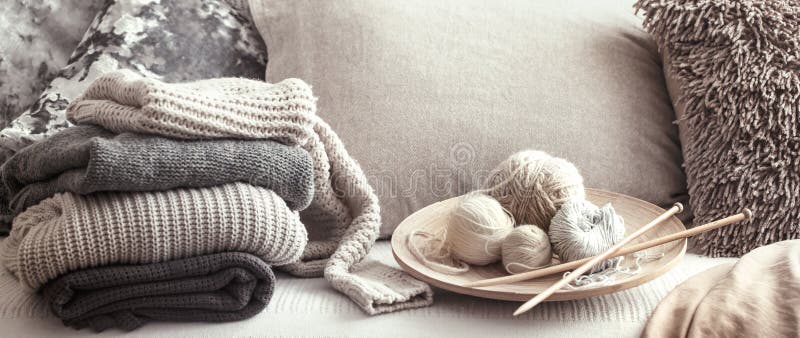 Εκλεκτής ποιότητας ξύλινα πλέκοντας βελόνες και νήματα για το πλέξιμο σε έναν άνετο καναπέ με τα μαξιλάρια και τα πουλόβερ στοκ εικόνα με δικαίωμα ελεύθερης χρήσης Εκλεκτής ποιότητας ξύλινα πλέκοντας βελόνες και νήματα για το πλέξιμο σε έναν άνετο καναπέ με τα μαξιλάρια και τα πουλόβερ στοκ εικόνα με δικαίωμα ελεύθερης χρήσης