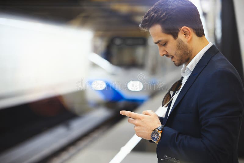 Ελκυστικό texting μήνυμα επιχειρηματιών στο κινητό τηλέφωνο περιμένοντας το τραίνο στο μετρό στοκ φωτογραφίες με δικαίωμα ελεύθερης χρήσης Ελκυστικό texting μήνυμα επιχειρηματιών στο κινητό τηλέφωνο περιμένοντας το τραίνο στο μετρό στοκ φωτογραφίες με δικαίωμα ελεύθερης χρήσης