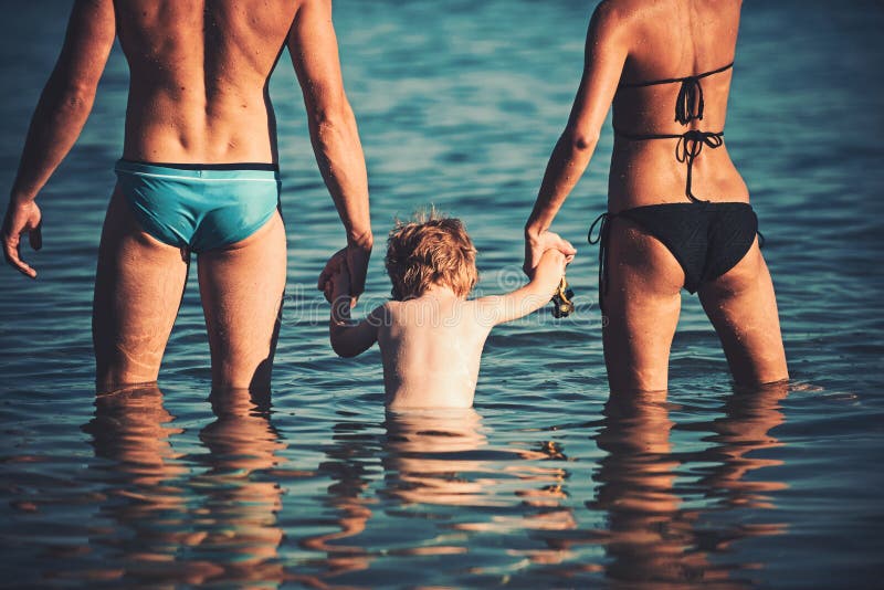 Ευτυχής οικογένεια στη θάλασσα που έχει τη διασκέδαση στο νερό, τη μητέρα και τον πατέρα με το παιδί που απολαμβάνει το παραθαλάσ στοκ εικόνα Ευτυχής οικογένεια στη θάλασσα που έχει τη διασκέδαση στο νερό, τη μητέρα και τον πατέρα με το παιδί που απολαμβάνει το παραθαλάσ στοκ εικόνα