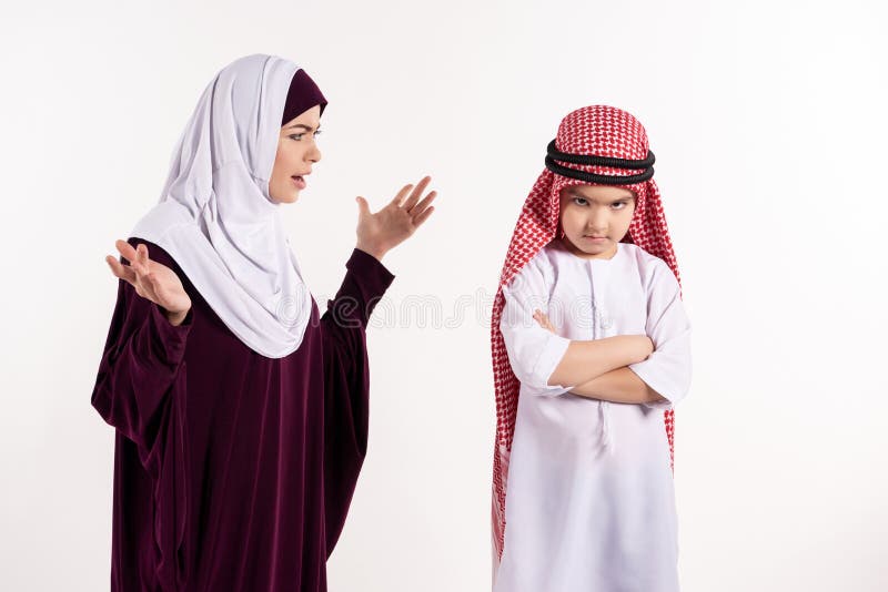 Η αραβική γυναίκα στο hijab επιπλήττει το αγόρι στο keffiyeh στοκ εικόνες Η αραβική γυναίκα στο hijab επιπλήττει το αγόρι στο keffiyeh στοκ εικόνες