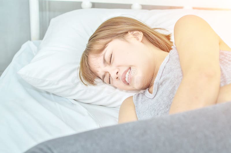 Η ασιατική φθορά γυναικών γκρίζα στο κρεβάτι είναι επίπονη στοκ εικόνα με δικαίωμα ελεύθερης χρήσης Η ασιατική φθορά γυναικών γκρίζα στο κρεβάτι είναι επίπονη στοκ εικόνα με δικαίωμα ελεύθερης χρήσης