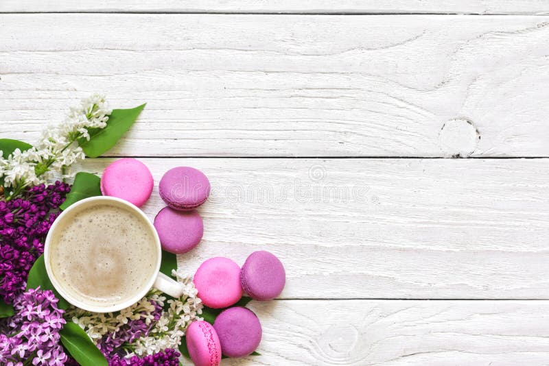 Η ιώδης ανθοδέσμη λουλουδιών άνοιξη με τα macarons και το cappuccino κοιλαίνουν στον άσπρο ξύλινο πίνακα με το διάστημα αντιγράφω στοκ εικόνες Η ιώδης ανθοδέσμη λουλουδιών άνοιξη με τα macarons και το cappuccino κοιλαίνουν στον άσπρο ξύλινο πίνακα με το διάστημα αντιγράφω στοκ εικόνες