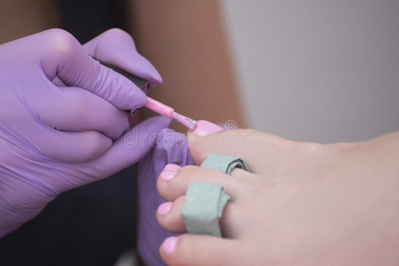 Κάλυψη toenails με τη ρόδινη στιλβωτική ουσία καρφιών Κινηματογράφηση σε πρώτο πλάνο Σαλόνι μανικιούρ στοκ φωτογραφία με δικαίωμα ελεύθερης χρήσης Κάλυψη toenails με τη ρόδινη στιλβωτική ουσία καρφιών Κινηματογράφηση σε πρώτο πλάνο Σαλόνι μανικιούρ στοκ φωτογραφία με δικαίωμα ελεύθερης χρήσης