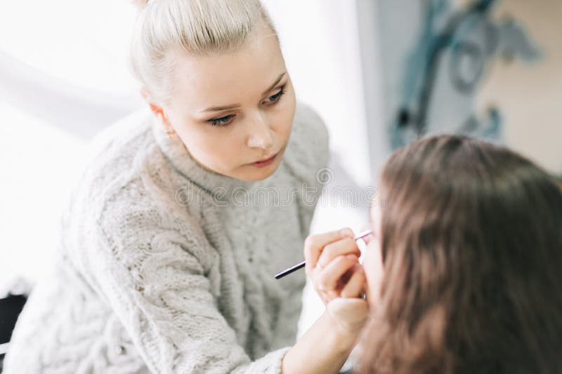 Καλλιτέχνης Makeup που προετοιμάζει τη νύφη πριν από το γάμο ένα πρωί στοκ εικόνες Καλλιτέχνης Makeup που προετοιμάζει τη νύφη πριν από το γάμο ένα πρωί στοκ εικόνες