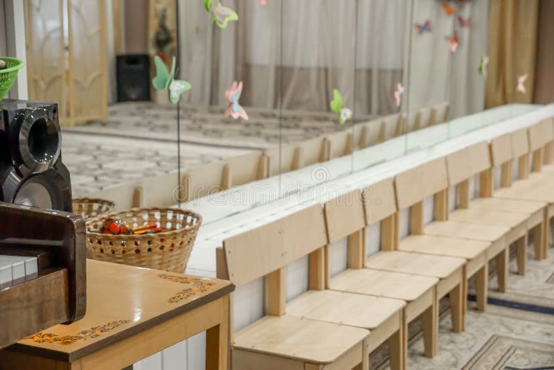 Κενή σειρά των ξύλινων καρεκλών παιδιών στο δωμάτιο μουσικής πριν από τον εορτασμό στο περιμένοντας κόμμα μεγάρων μουσικής στοκ εικόνα με δικαίωμα ελεύθερης χρήσης Κενή σειρά των ξύλινων καρεκλών παιδιών στο δωμάτιο μουσικής πριν από τον εορτασμό στο περιμένοντας κόμμα μεγάρων μουσικής στοκ εικόνα με δικαίωμα ελεύθερης χρήσης