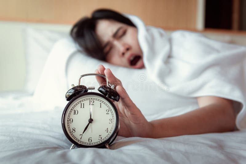 Κλείνοντας τον ήχο ή Snoozing η έννοια ξυπνητηριών, όμορφη γυναίκα που ξυπνά το πρωί στην κρεβατοκάμαρα ενώ το χέρι της είναι στοκ εικόνες Κλείνοντας τον ήχο ή Snoozing η έννοια ξυπνητηριών, όμορφη γυναίκα που ξυπνά το πρωί στην κρεβατοκάμαρα ενώ το χέρι της είναι στοκ εικόνες