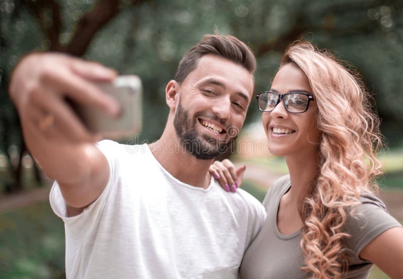 κλείστε επάνω χαμογελώντας νέο ζεύγος που παίρνει selfie στο πάρκο πόλεων στοκ εικόνα κλείστε επάνω χαμογελώντας νέο ζεύγος που παίρνει selfie στο πάρκο πόλεων στοκ εικόνα