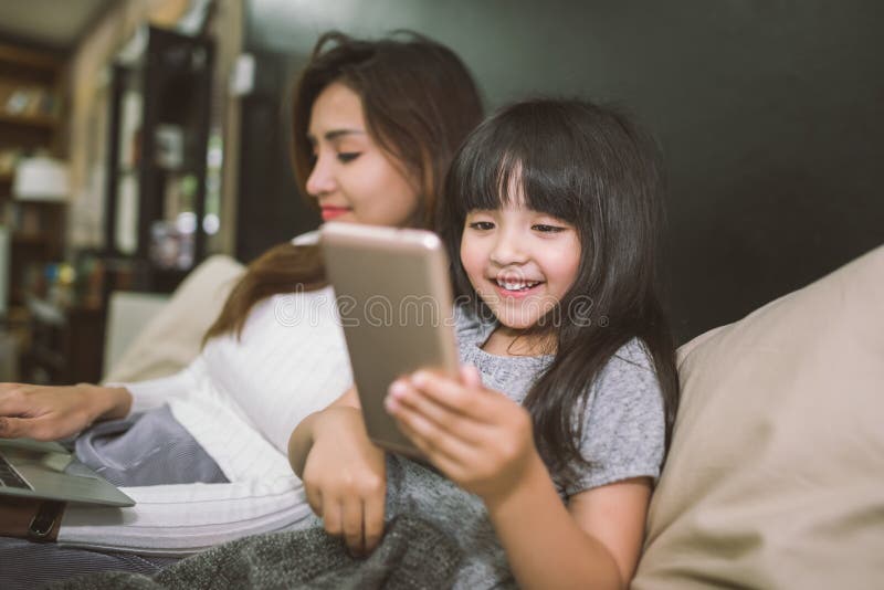 Μητέρα και κόρη που χρησιμοποιούν το smartphone και το lap-top μαζί στην κρεβατοκάμαρα απομονωμένο έννοια λευκό τεχνολογίας στοκ εικόνα με δικαίωμα ελεύθερης χρήσης Μητέρα και κόρη που χρησιμοποιούν το smartphone και το lap-top μαζί στην κρεβατοκάμαρα απομονωμένο έννοια λευκό τεχνολογίας στοκ εικόνα με δικαίωμα ελεύθερης χρήσης