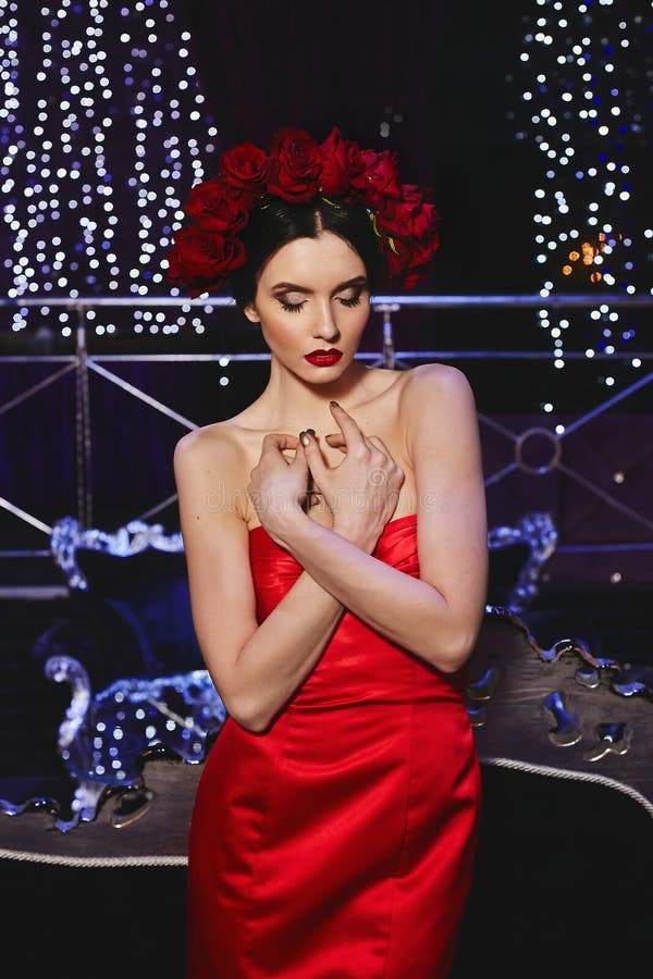 Μοντέρνο λεπτό πρότυπο κορίτσι brunette με το φωτεινό makeup και με ένα κόκκινο floral στεφάνι στο κεφάλι της στο κόκκινο μοντέρν στοκ εικόνες Μοντέρνο λεπτό πρότυπο κορίτσι brunette με το φωτεινό makeup και με ένα κόκκινο floral στεφάνι στο κεφάλι της στο κόκκινο μοντέρν στοκ εικόνες