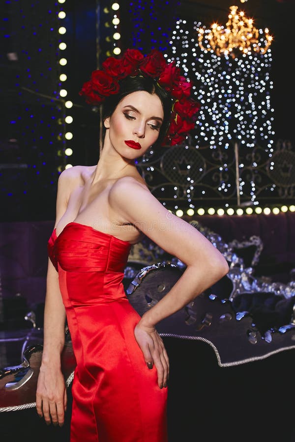 Μοντέρνο λεπτό πρότυπο κορίτσι brunette με το φωτεινό makeup και με ένα κόκκινο floral στεφάνι στο κεφάλι της στο κόκκινο μοντέρν στοκ εικόνες Μοντέρνο λεπτό πρότυπο κορίτσι brunette με το φωτεινό makeup και με ένα κόκκινο floral στεφάνι στο κεφάλι της στο κόκκινο μοντέρν στοκ εικόνες