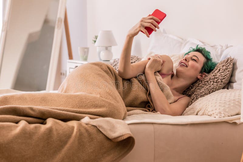 Νέα γυναίκα που κάνει selfie για το φίλο στο κρεβάτι στοκ εικόνα με δικαίωμα ελεύθερης χρήσης Νέα γυναίκα που κάνει selfie για το φίλο στο κρεβάτι στοκ εικόνα με δικαίωμα ελεύθερης χρήσης