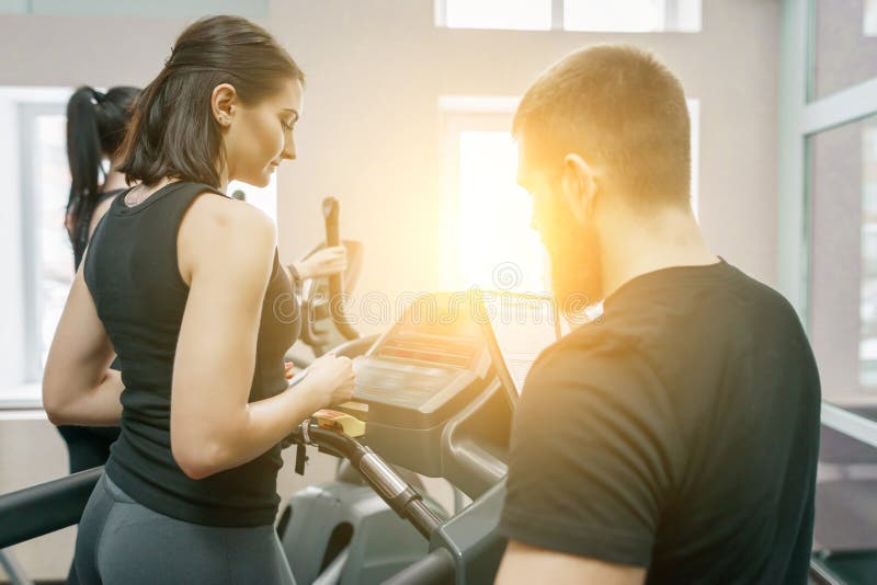 Νέες αθλητικές γυναίκες treadmill, προσωπικός εκπαιδευτικός που προγυμνάζουν και που βοηθούν τη γυναίκα πελατών Ικανότητα, αθλητι στοκ φωτογραφία με δικαίωμα ελεύθερης χρήσης Νέες αθλητικές γυναίκες treadmill, προσωπικός εκπαιδευτικός που προγυμνάζουν και που βοηθούν τη γυναίκα πελατών Ικανότητα, αθλητι στοκ φωτογραφία με δικαίωμα ελεύθερης χρήσης