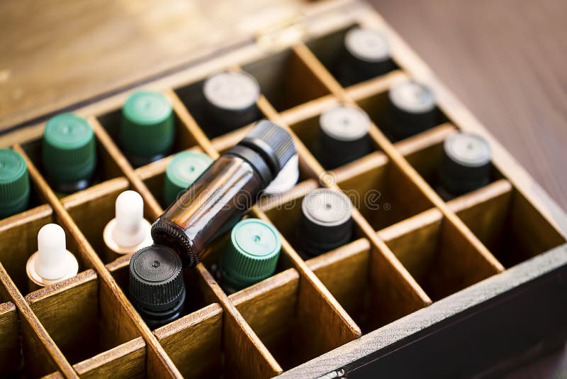 Ουσιαστικά πετρέλαια Aromatherapy στο ξύλινο κιβώτιο Βοτανική εναλλακτική ιατρική με τα μπουκάλια ουσιαστικών πετρελαίων στο ξύλι στοκ φωτογραφία με δικαίωμα ελεύθερης χρήσης