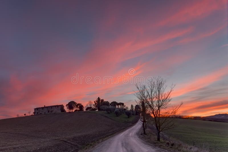 Ένα θεαματικό ηλιοβασίλεμα περιβάλλει το Tuscan νότο επαρχίας της Σιένα, Ιταλία στοκ φωτογραφία με δικαίωμα ελεύθερης χρήσης Ένα θεαματικό ηλιοβασίλεμα περιβάλλει το Tuscan νότο επαρχίας της Σιένα, Ιταλία στοκ φωτογραφία με δικαίωμα ελεύθερης χρήσης