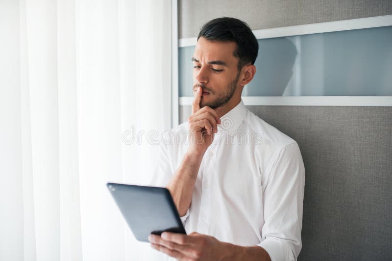 Όμορφη brunet εργασία επιχειρηματιών, έρευνα, που διαβάζει στη συσκευή, συσκευή στο γραφείο στοκ εικόνες