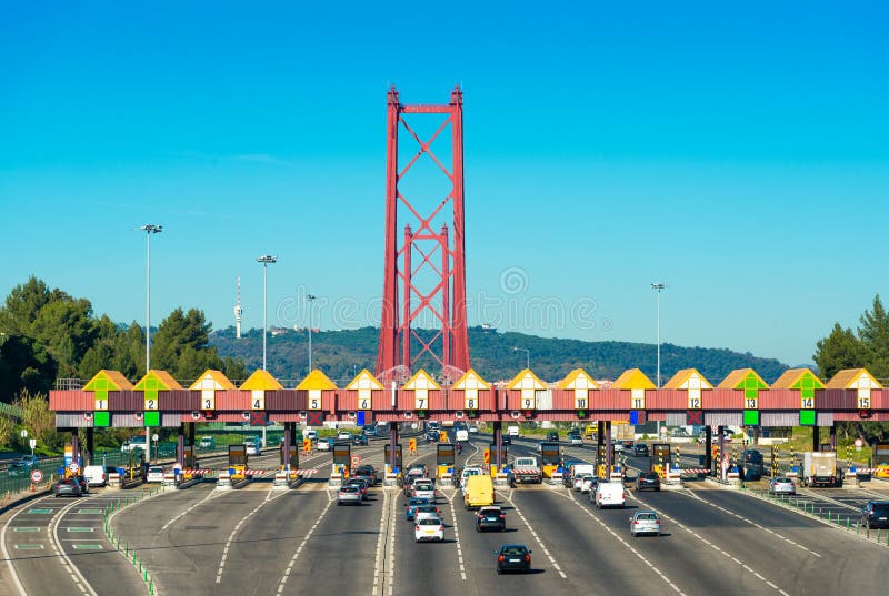 Σταθμός φόρου στην είσοδο στη γέφυρα στις 25 Απριλίου μεταξύ της Λισσαβώνας και της Αλμάντα, Πορτογαλία Αυτοκίνητα που περνούν μέ στοκ φωτογραφία Σταθμός φόρου στην είσοδο στη γέφυρα στις 25 Απριλίου μεταξύ της Λισσαβώνας και της Αλμάντα, Πορτογαλία Αυτοκίνητα που περνούν μέ στοκ φωτογραφία