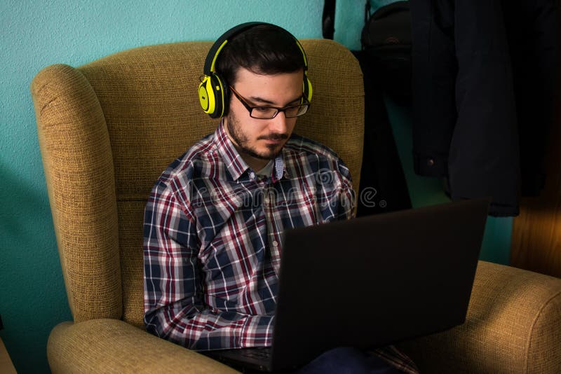 Το άτομο χρησιμοποιεί το lap-top στον καναπέ στο σπίτι του στοκ φωτογραφία με δικαίωμα ελεύθερης χρήσης Το άτομο χρησιμοποιεί το lap-top στον καναπέ στο σπίτι του στοκ φωτογραφία με δικαίωμα ελεύθερης χρήσης