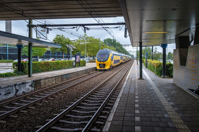 Το ολλανδικό intercity τραίνο φθάνει στο σιδηροδρομικό σταθμό στοκ εικόνες με δικαίωμα ελεύθερης χρήσης Το ολλανδικό intercity τραίνο φθάνει στο σιδηροδρομικό σταθμό στοκ εικόνες με δικαίωμα ελεύθερης χρήσης
