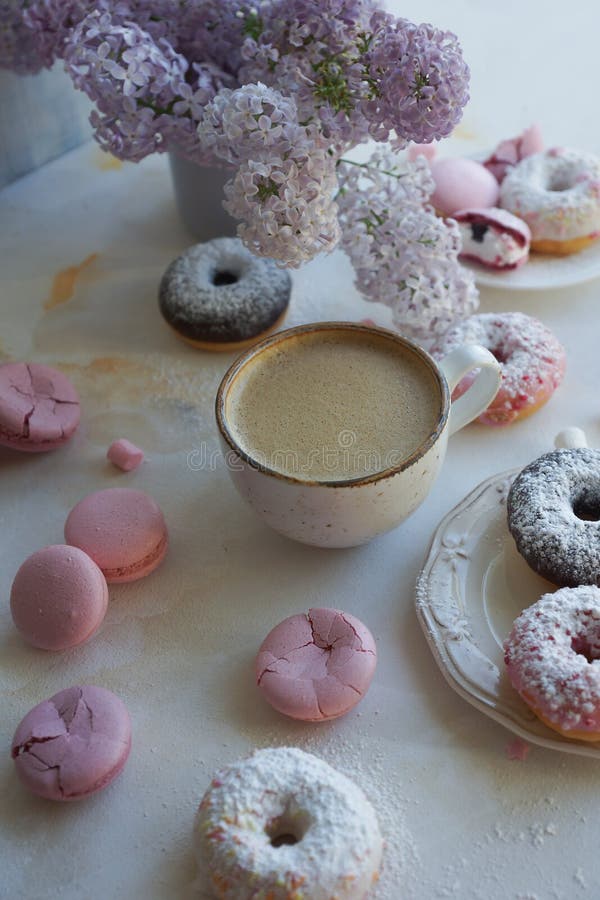 Φλυτζάνι του cappuccino, των φρέσκων ζωηρόχρωμων donuts, της φράουλας macarons και της ανθοδέσμης της πασχαλιάς στον άσπρο μαρμάρ στοκ εικόνες Φλυτζάνι του cappuccino, των φρέσκων ζωηρόχρωμων donuts, της φράουλας macarons και της ανθοδέσμης της πασχαλιάς στον άσπρο μαρμάρ στοκ εικόνες