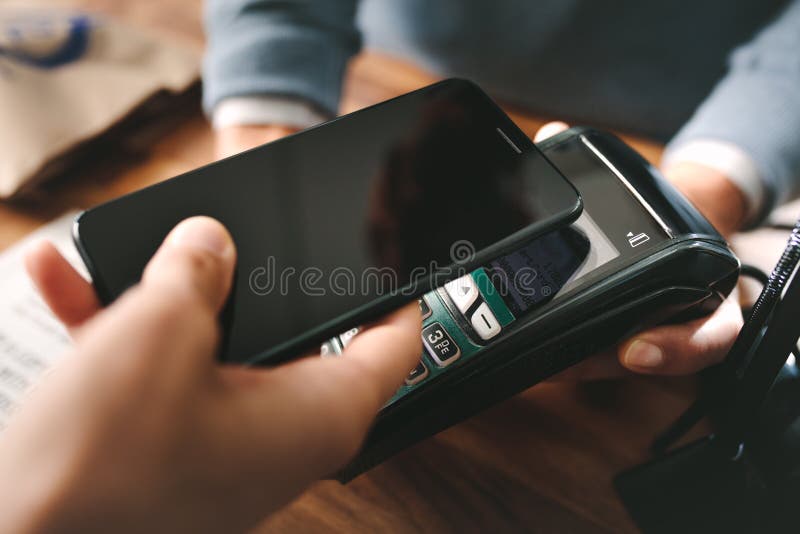 Πελάτης που πληρώνει μέσω του smartphone χρησιμοποιώντας την τεχνολογία NFC στοκ φωτογραφία με δικαίωμα ελεύθερης χρήσης Πελάτης που πληρώνει μέσω του smartphone χρησιμοποιώντας την τεχνολογία NFC στοκ φωτογραφία με δικαίωμα ελεύθερης χρήσης