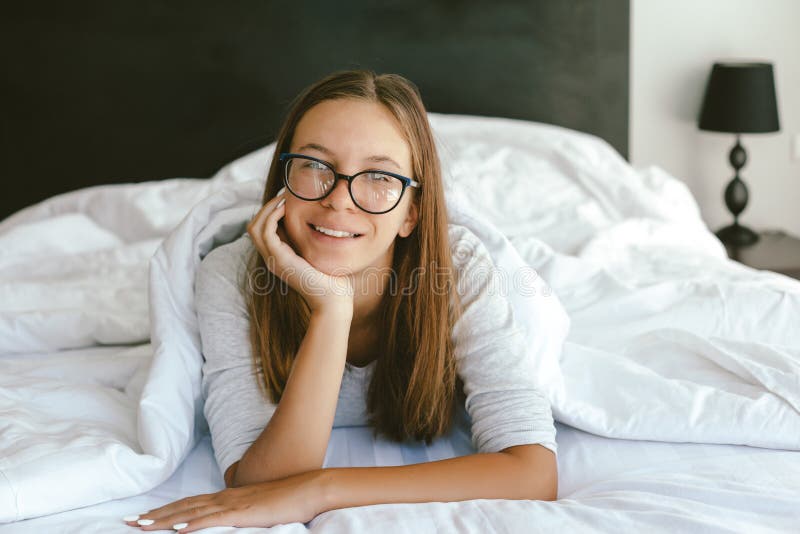Πορτρέτο ενός χρονών έφηβη 12-13-14 που φορά eyeglasses στο κρεβάτι στοκ φωτογραφία Πορτρέτο ενός χρονών έφηβη 12-13-14 που φορά eyeglasses στο κρεβάτι στοκ φωτογραφία