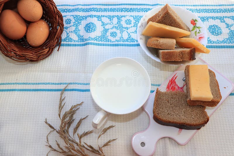Πρόγευμα χώρας, γάλα και ψωμί δημητριακών, φέτες του τυριού και φρέσκα αυγά σε ένα καλάθι στοκ εικόνα με δικαίωμα ελεύθερης χρήσης Πρόγευμα χώρας, γάλα και ψωμί δημητριακών, φέτες του τυριού και φρέσκα αυγά σε ένα καλάθι στοκ εικόνα με δικαίωμα ελεύθερης χρήσης