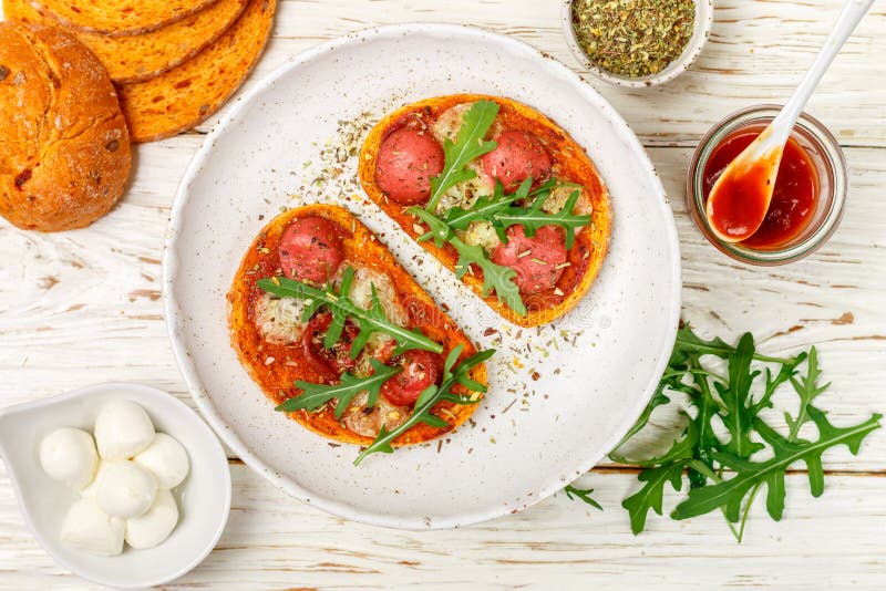 Домодельные открытые сэндвичи с сосиской, сыром моццареллы и свежим arugula стоковое изображение rf Домодельные открытые сэндвичи с сосиской, сыром моццареллы и свежим arugula стоковое изображение rf