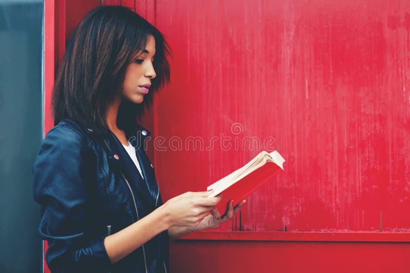 Ð stojący outdoors dla amerykańskiej kobiety czyta literaturę podczas gdy fotografia stock Ð stojący outdoors dla amerykańskiej kobiety czyta literaturę podczas gdy fotografia stock