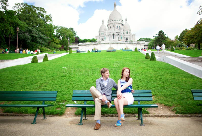Ð¡ouple is sittin on the bench near Sacre-Coeur